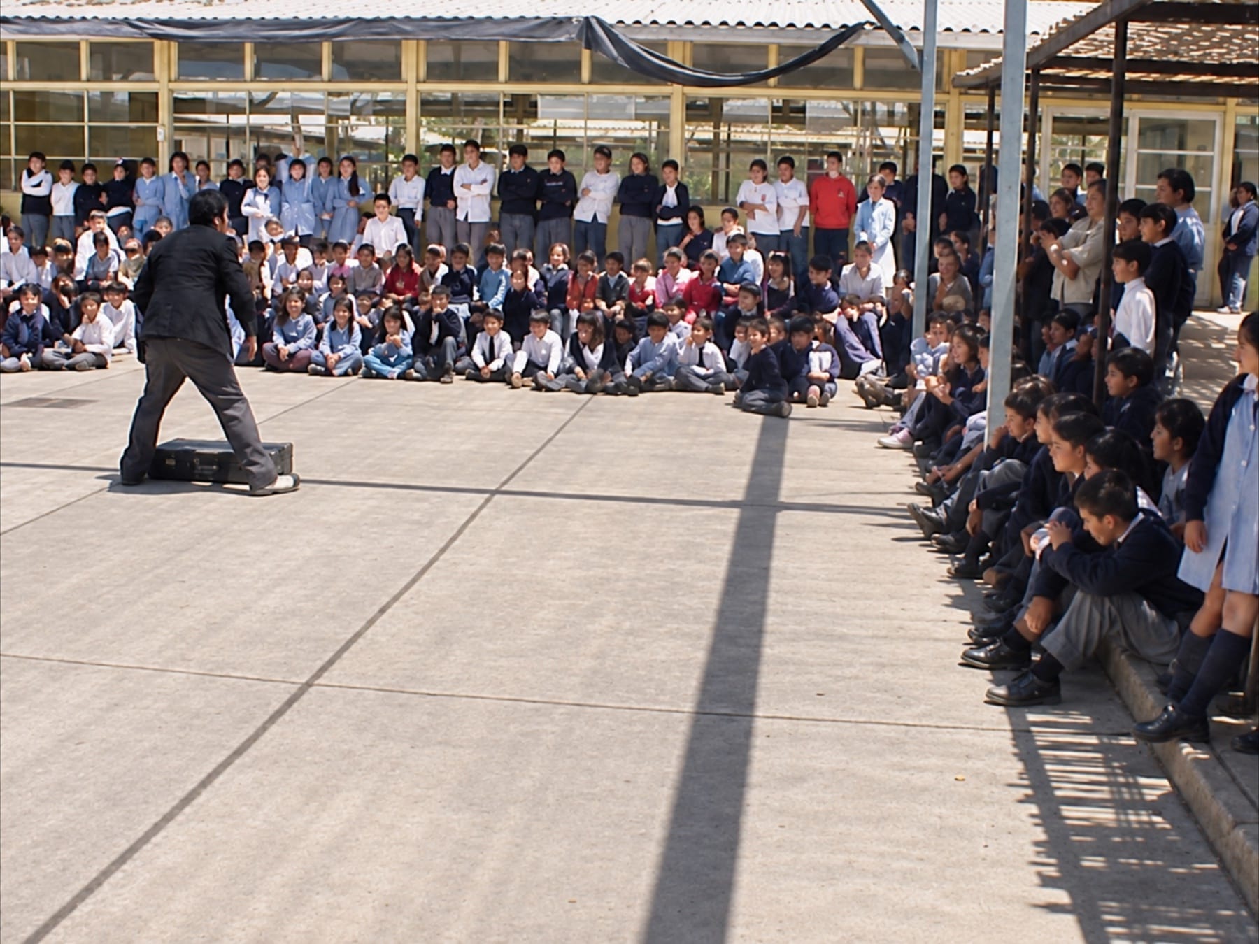 Comunidad escolar reunida durante una función de Maleta de payaso en el patio