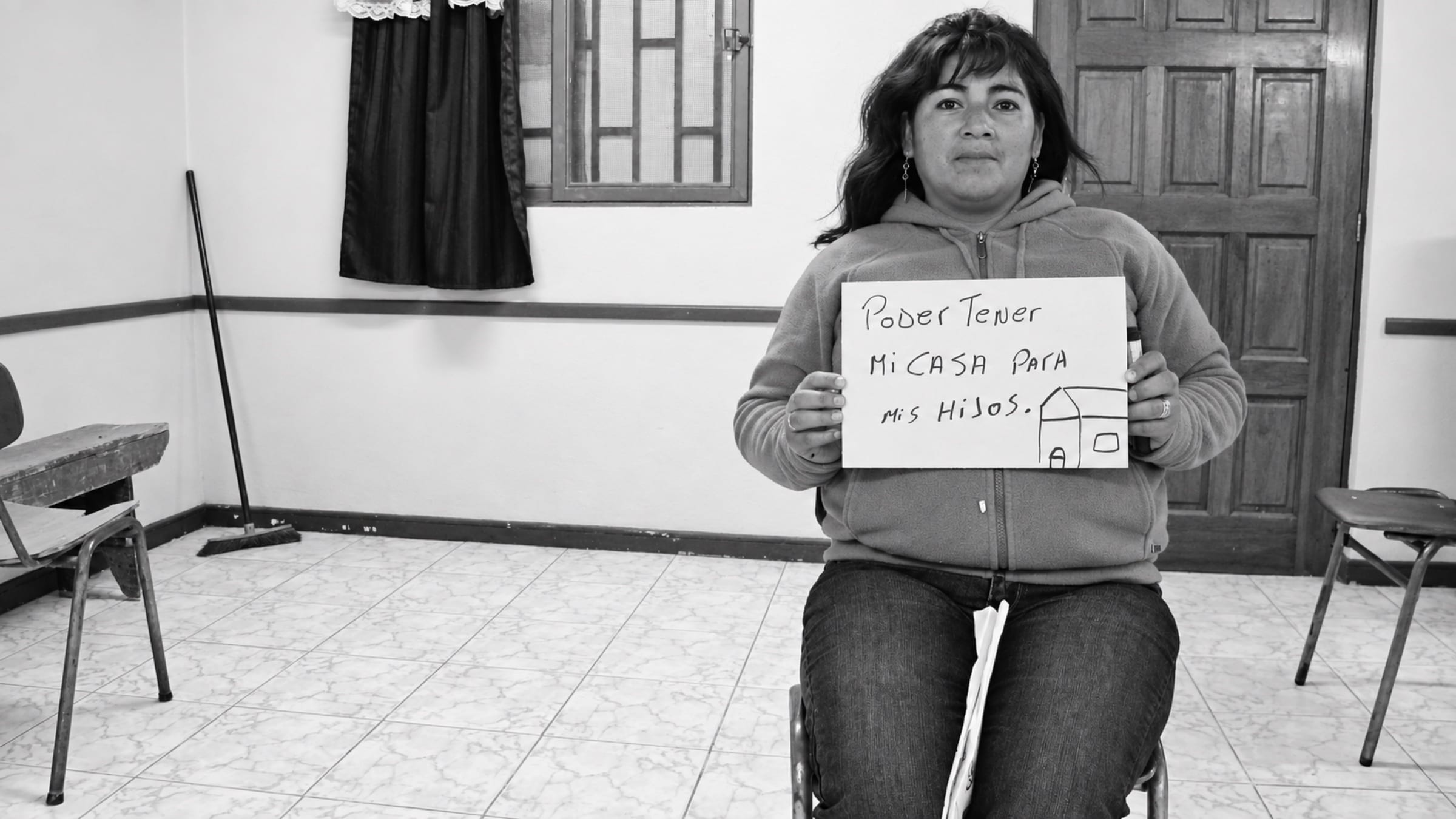 Participante de Vivo soñando sostiene un cartel con el sueño de tener una casa para sus hijos