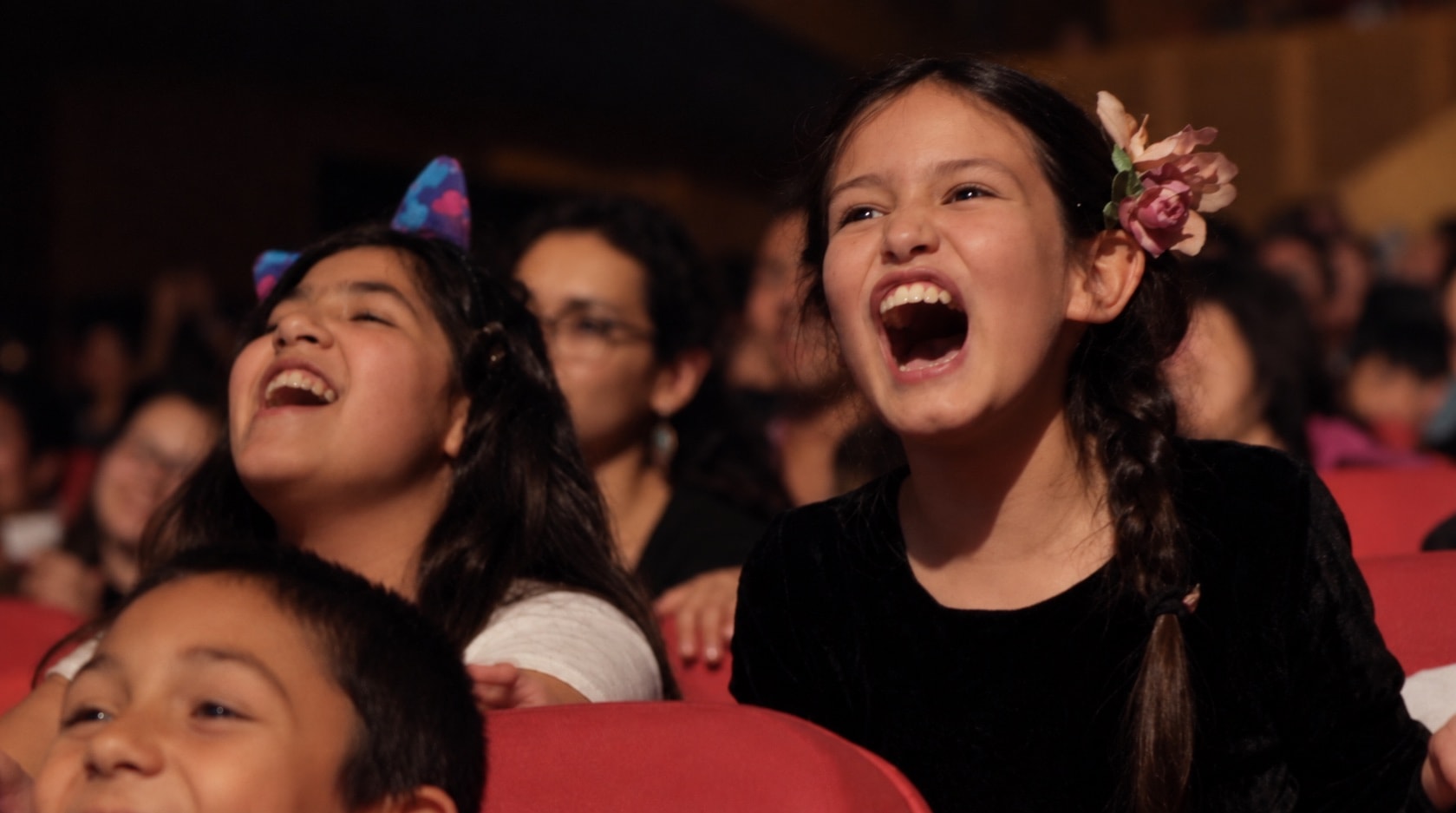 Niñas ríen mientras observan una experiencia de ilusionismo